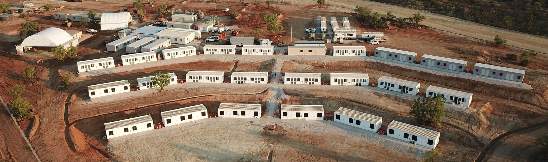 Aerial view of a complex of modular buildings in a barren, arid landscape.