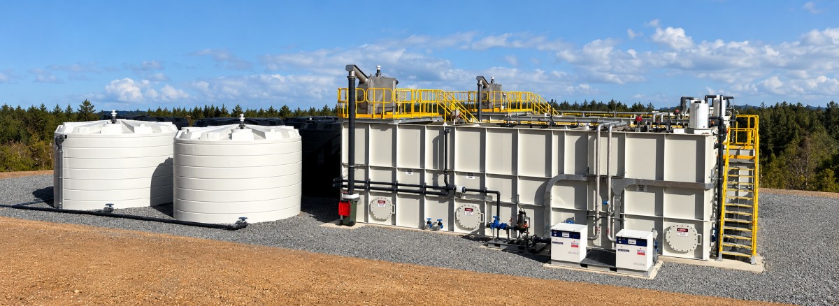 Industrial Centurion water tanks and water treatment equipment beside a gravel yard under a blue sky
