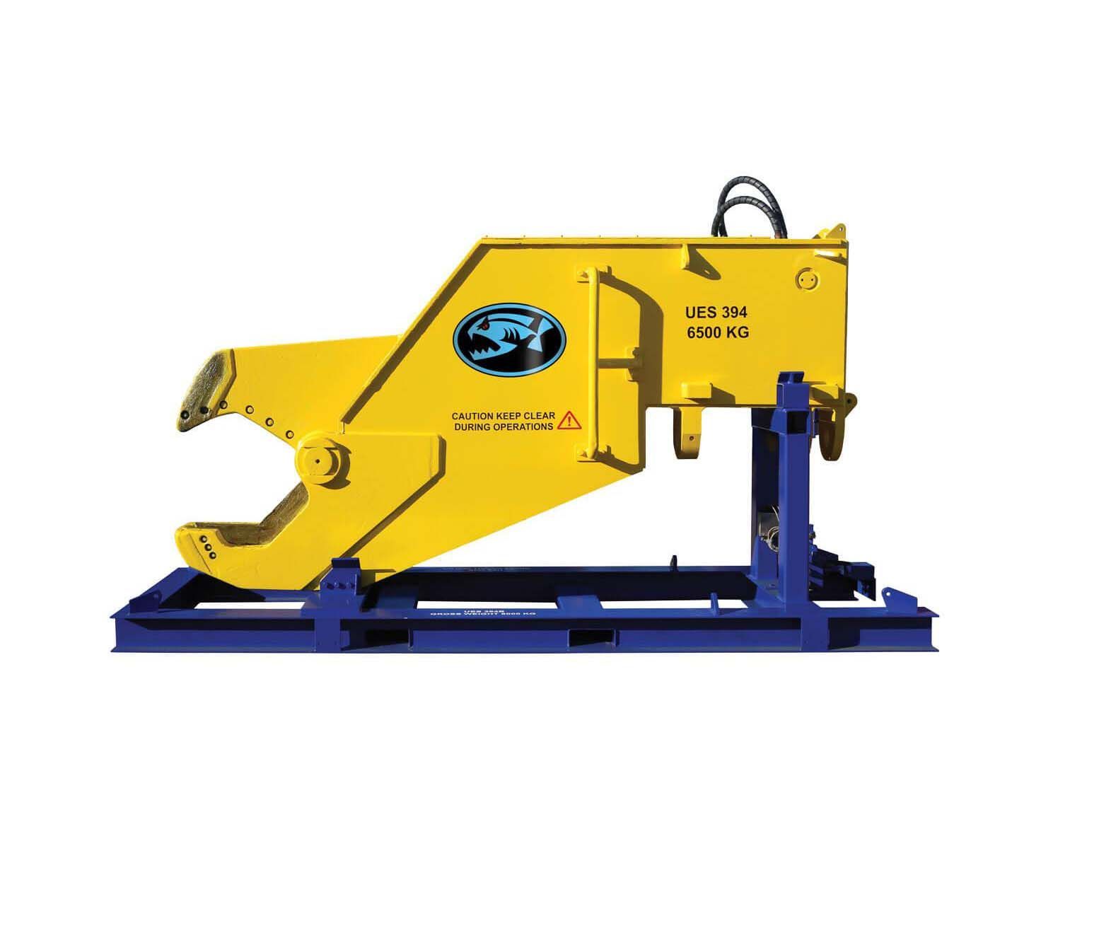 Yellow hydraulic concrete crusher attached to blue support frame.
