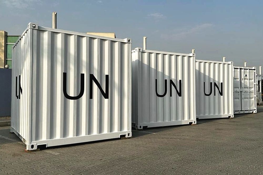 White UN shipping containers lined up outdoors on a paved lot under a blue sky manufactured by Centurion