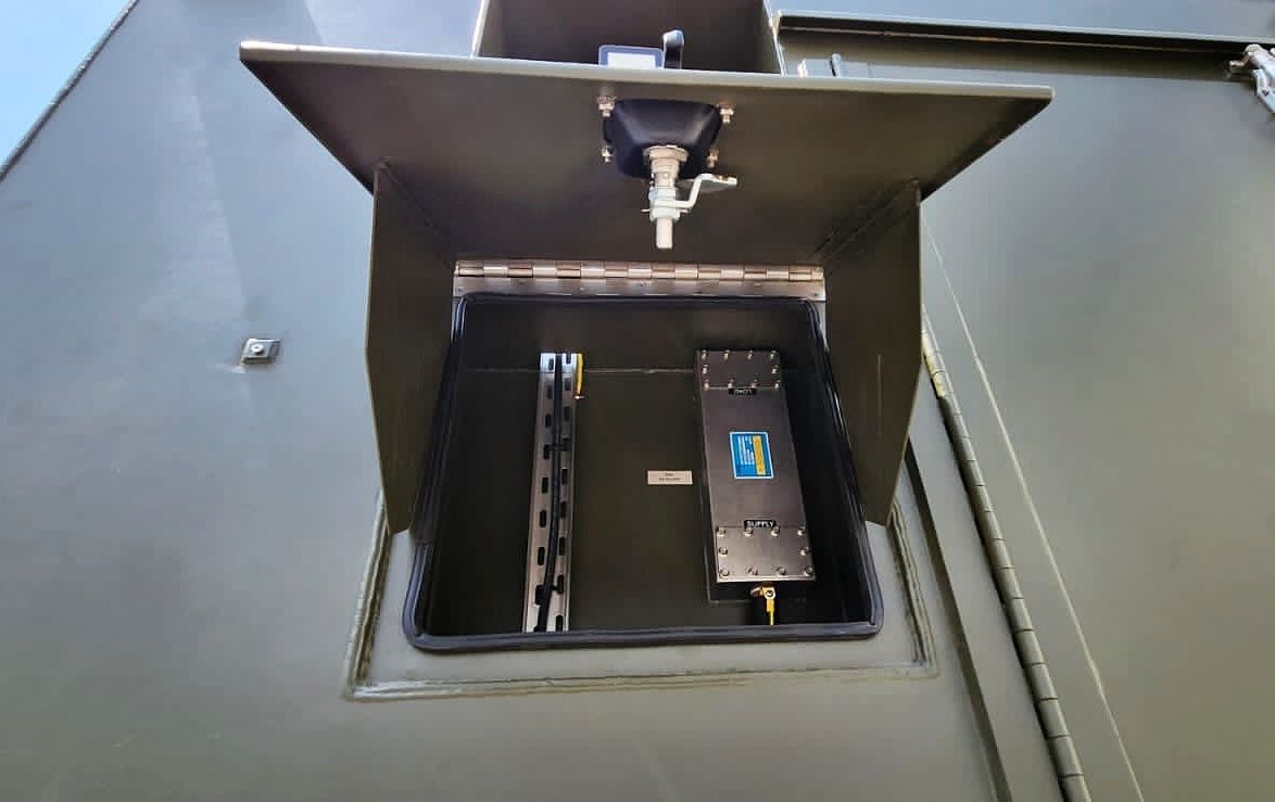 Open box on green surface revealing electronic equipment.