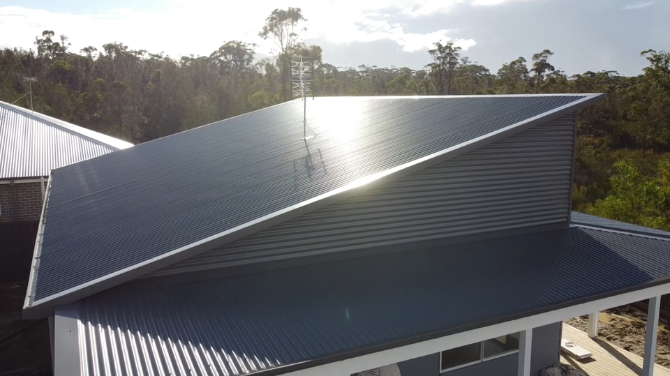 View of a newly installed dark-colored Colorbond roof on a house.