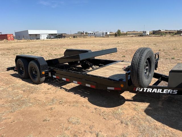 A trailer is parked in the middle of a dirt field.