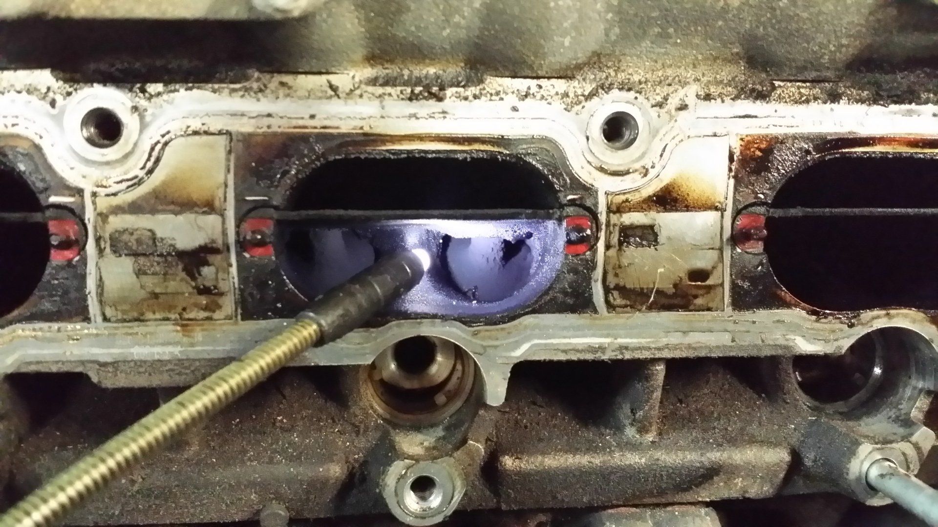 A close up of a car engine with a hose attached to it