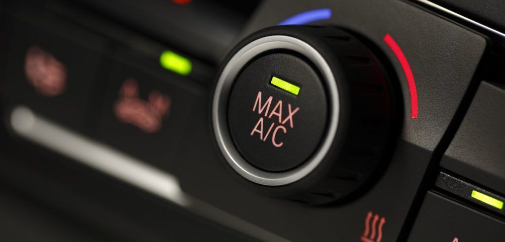 A close up of a max a/c button on a car dashboard