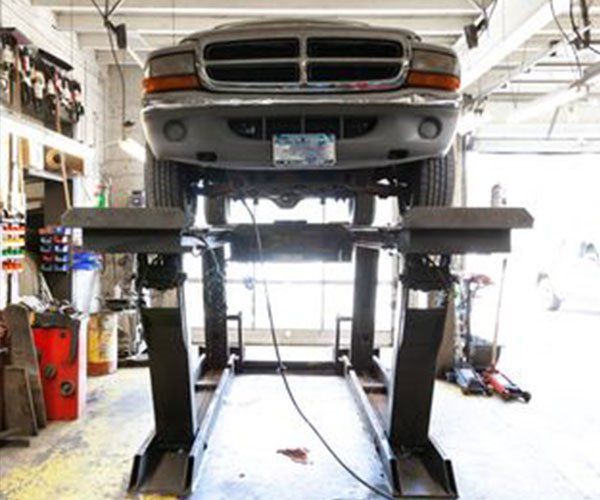A dodge truck is on a lift in a garage