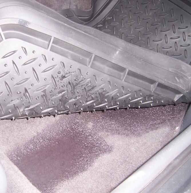 A close up of a dirty floor mat in a car.