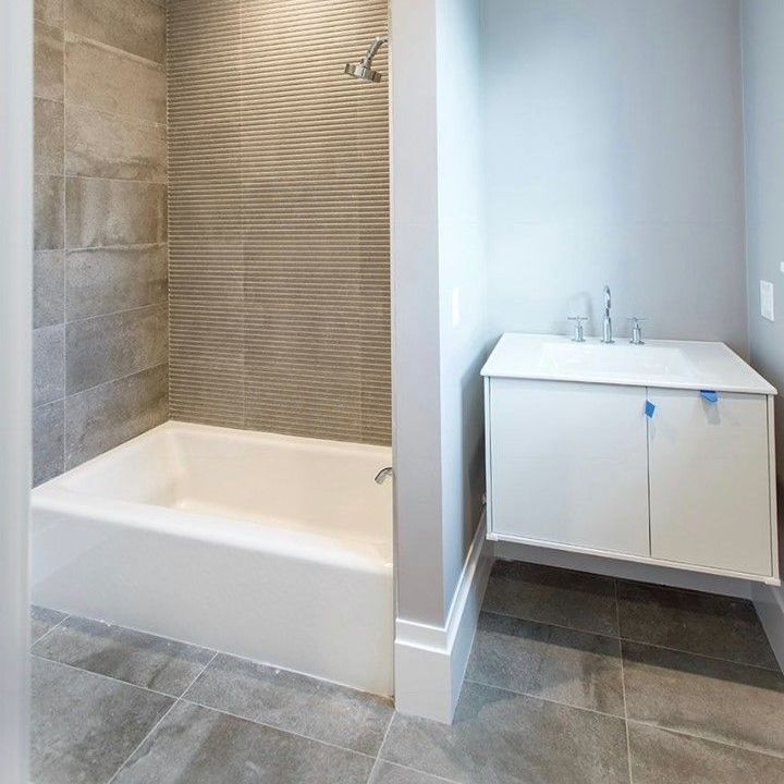 A bathroom with a bathtub , sink , and shower.