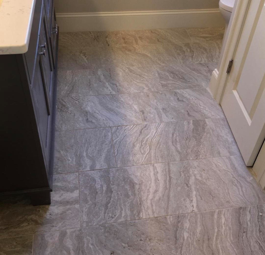 A bathroom with a tiled floor and a sink.