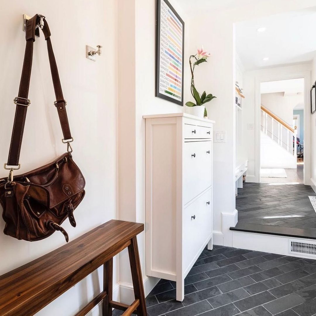 A brown purse hangs on a hook in a hallway