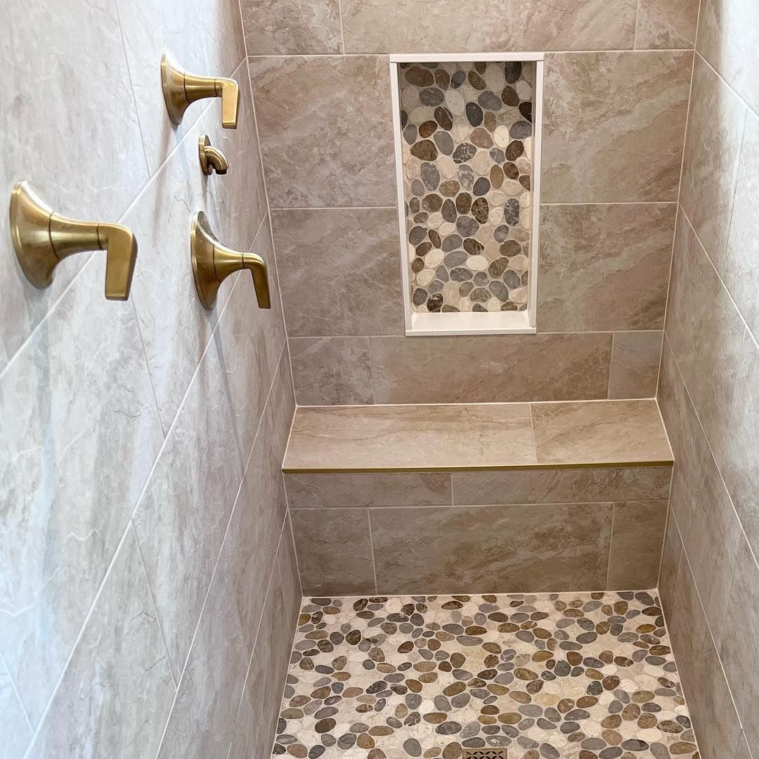 A bathroom with a walk in shower and a shelf