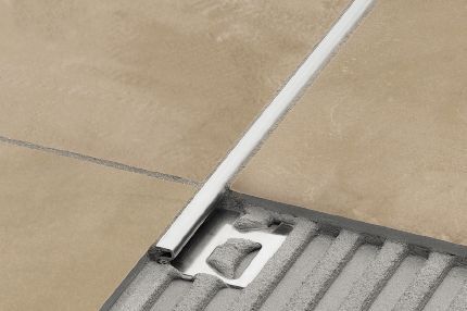 A close up of a tile border on a tiled floor.