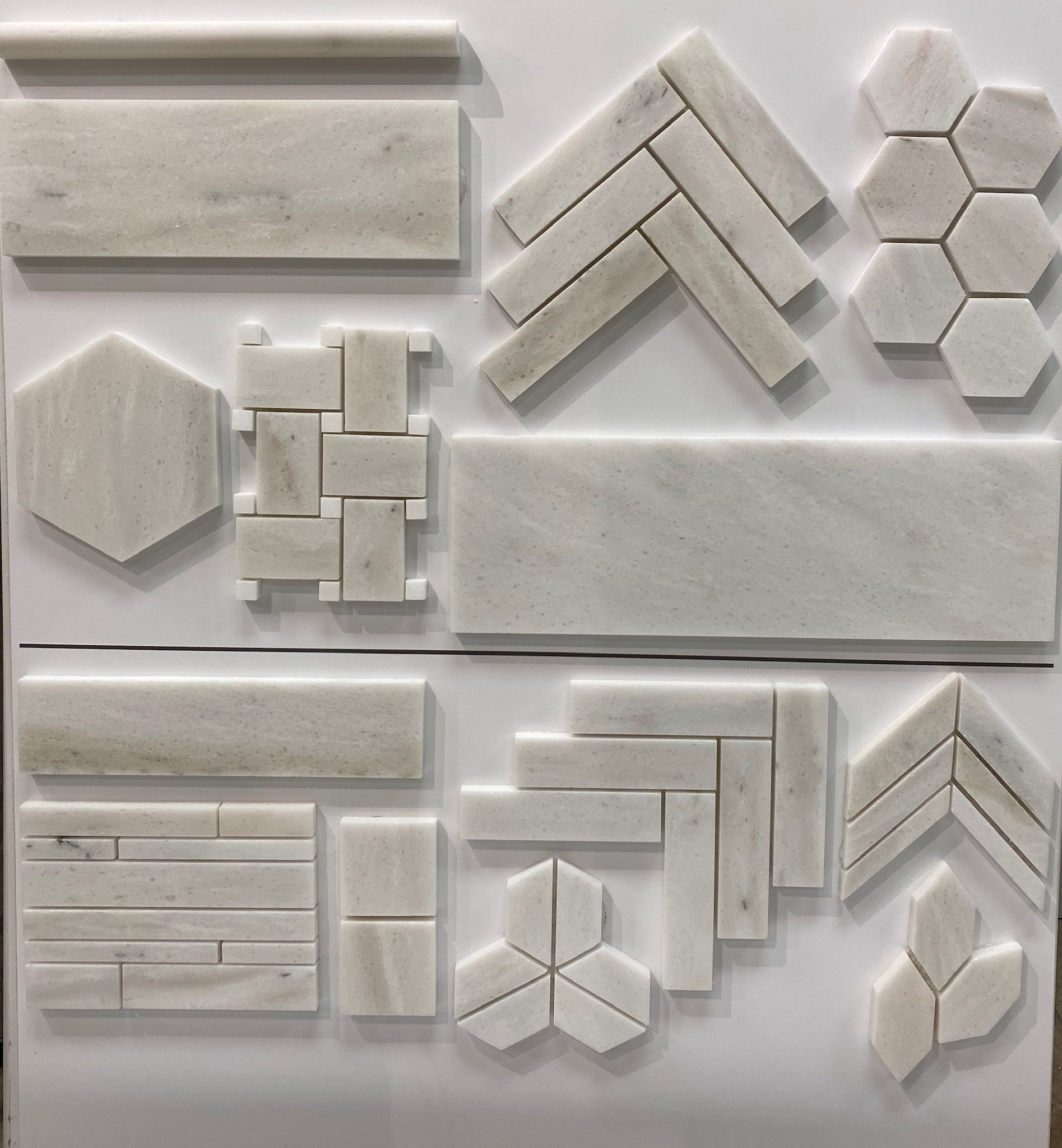 A variety of white tiles are displayed on a white surface