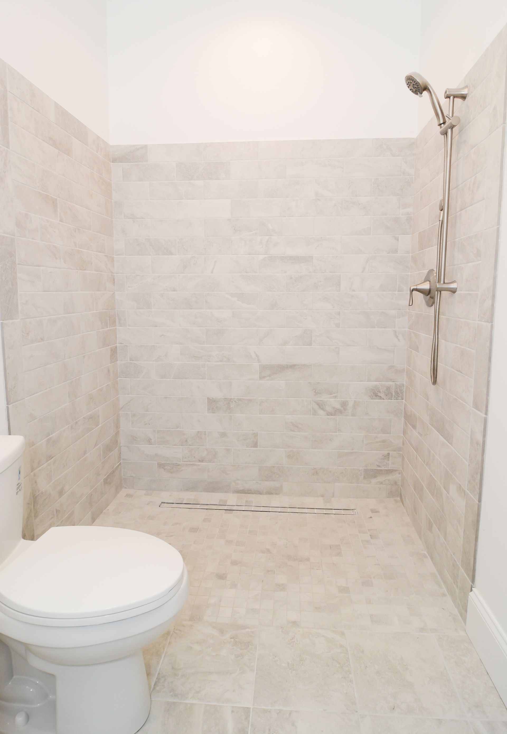 A bathroom with a toilet , sink and shower.