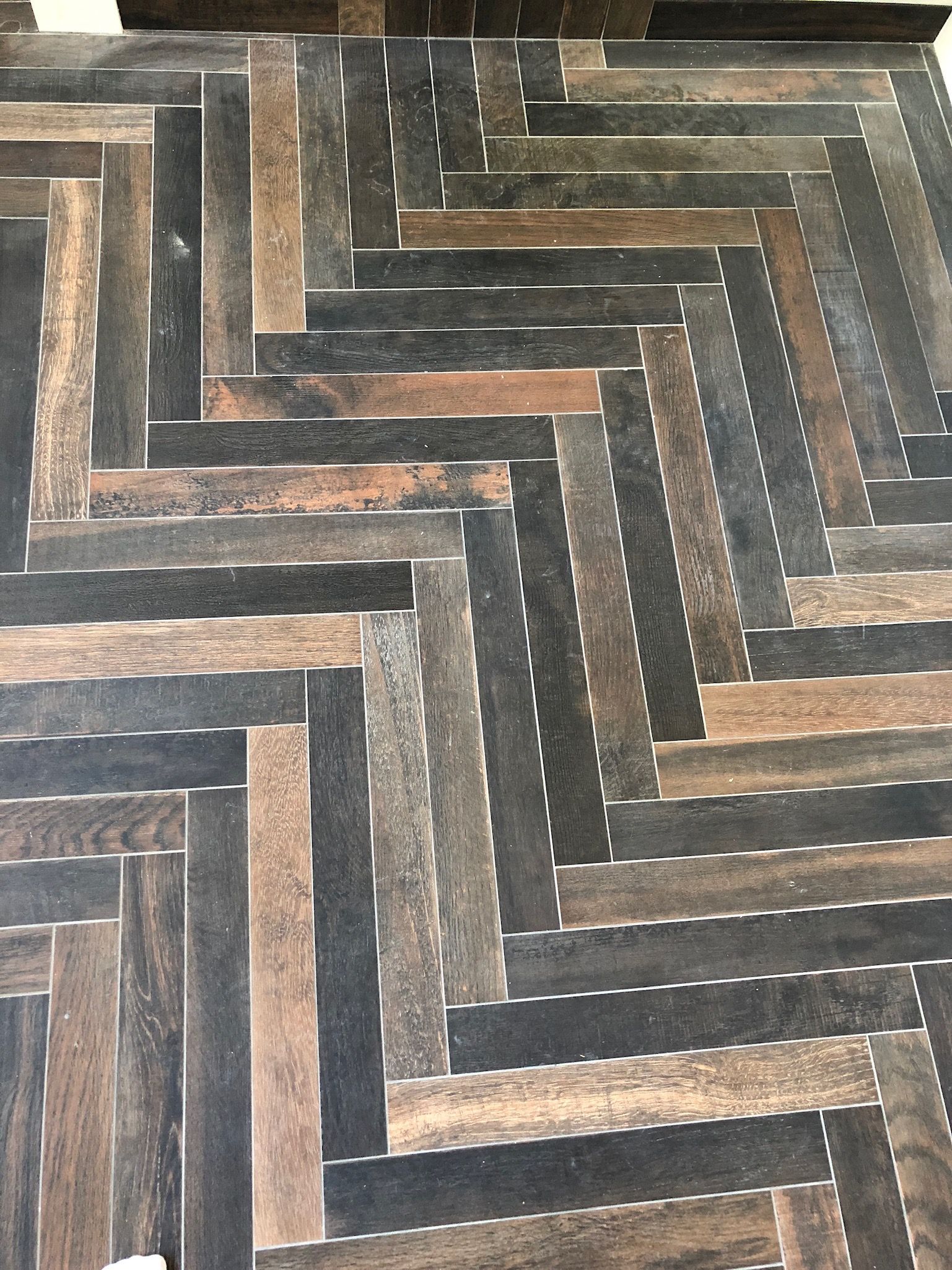 A close up of a wooden floor with a herringbone pattern