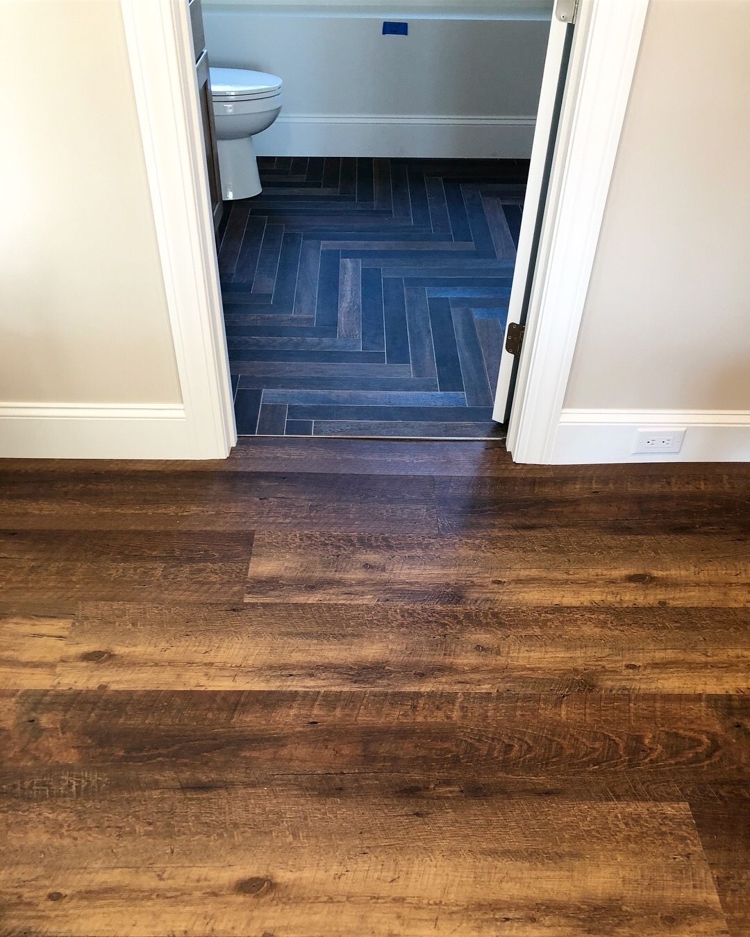 A bathroom with a wooden floor and a toilet.