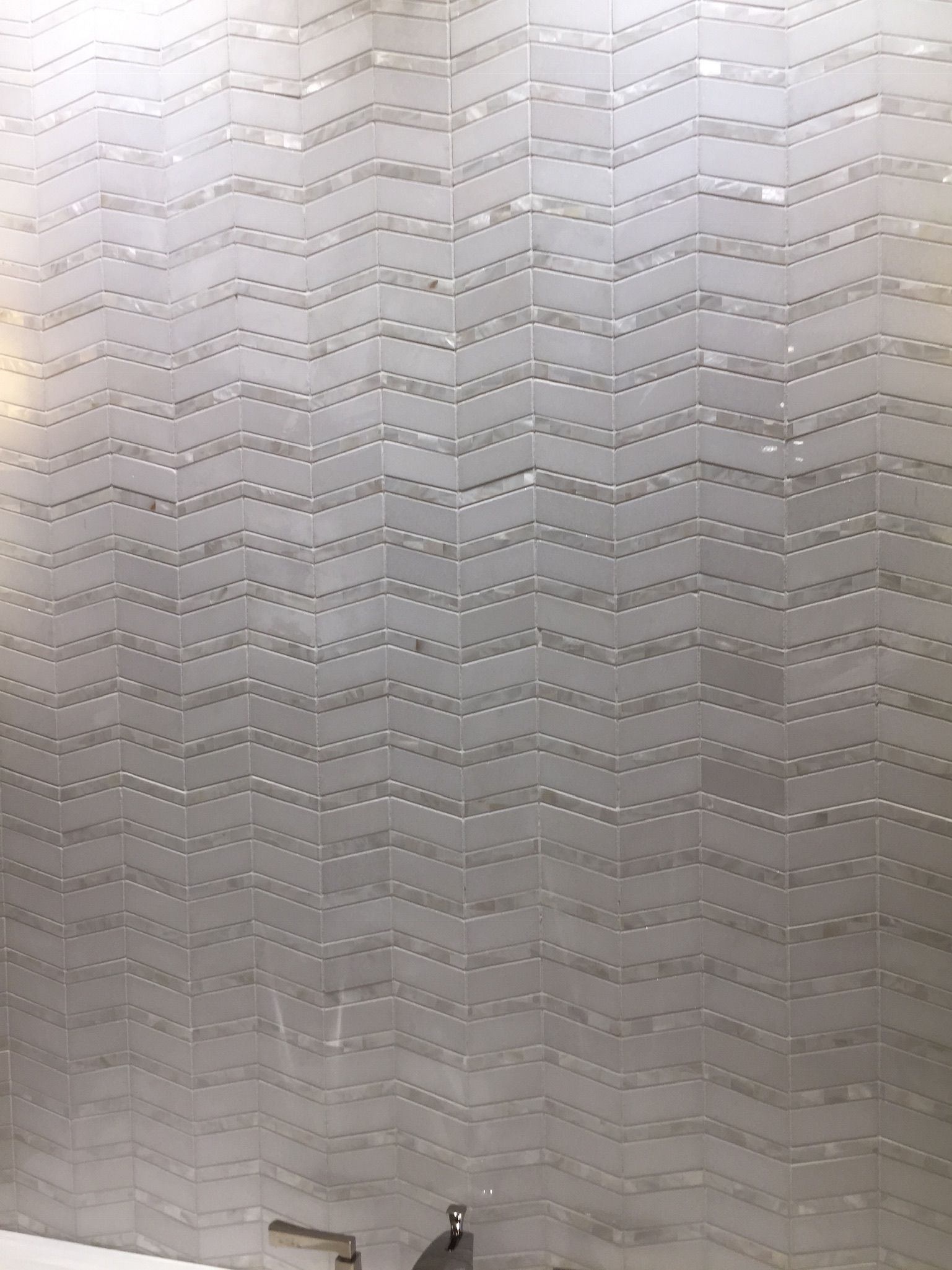 A close up of a stainless steel wall with a pattern on it.