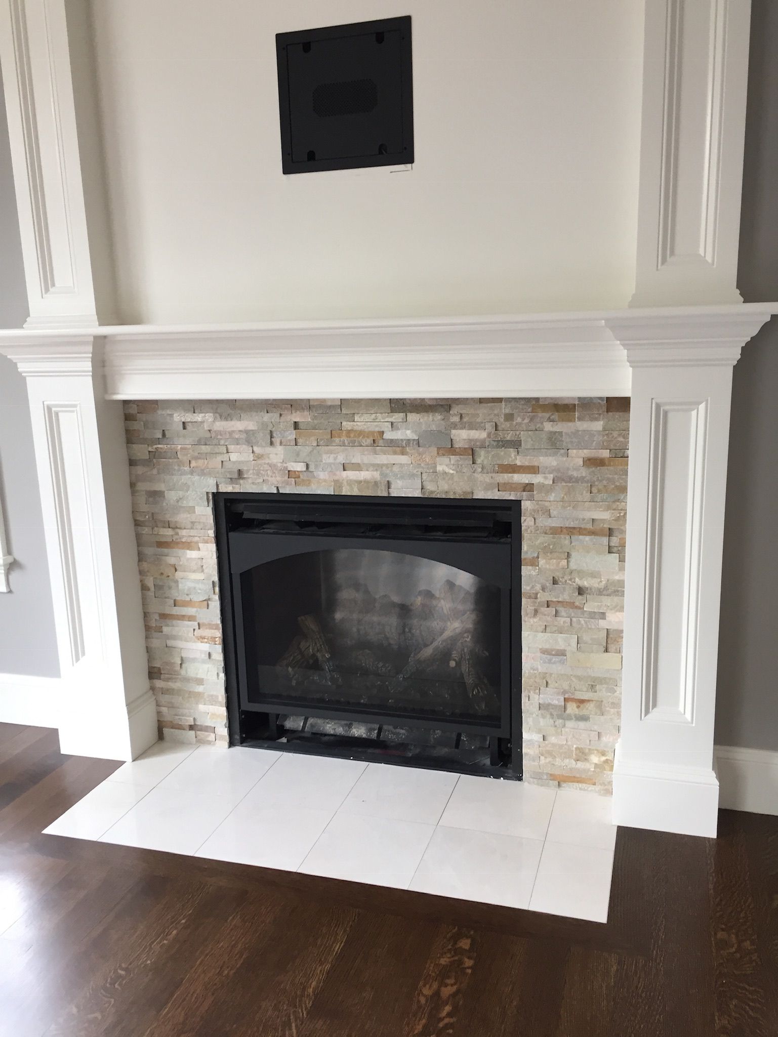 A fireplace in a living room with a white mantle