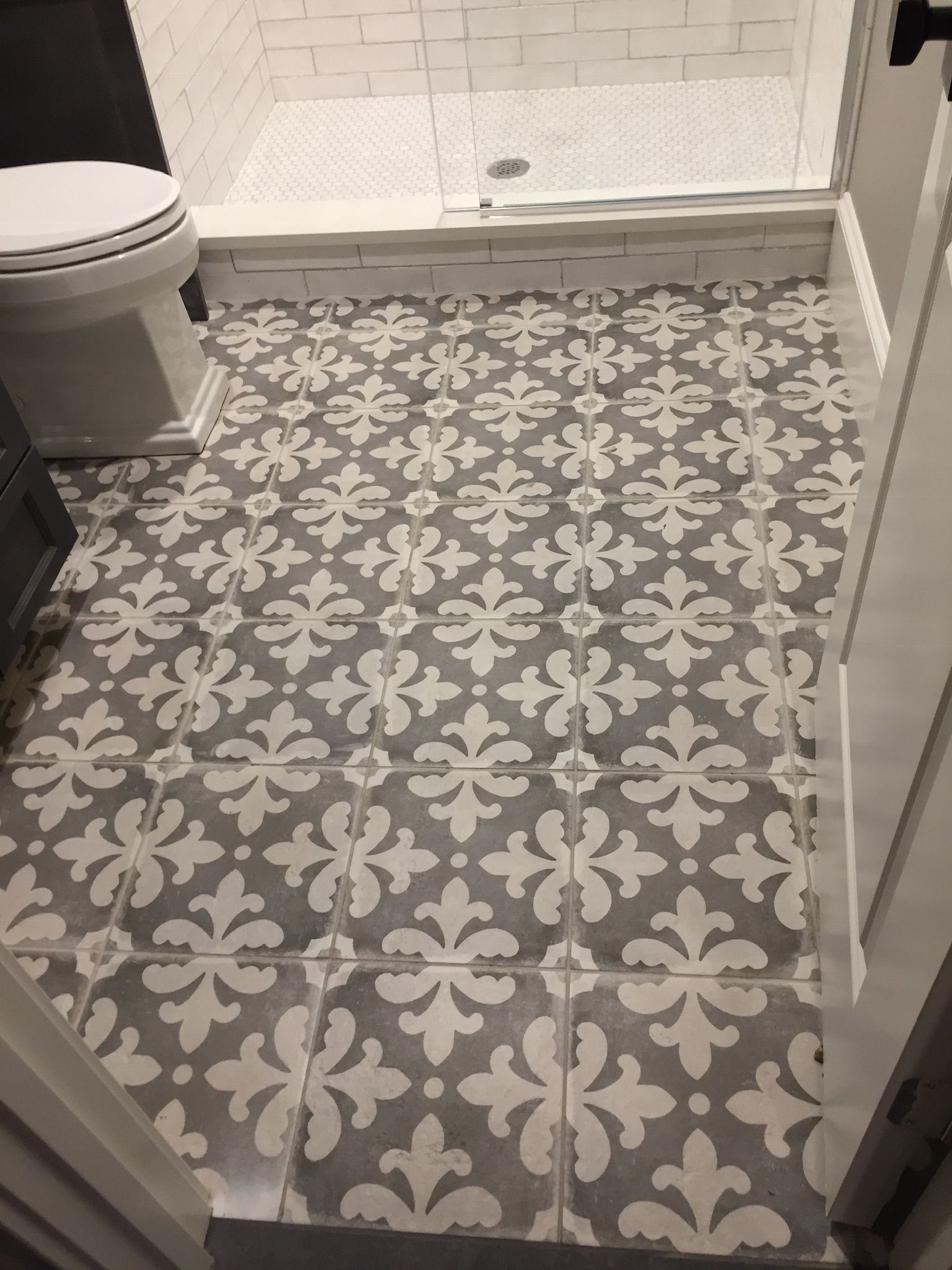 A bathroom with a tiled floor and a toilet.