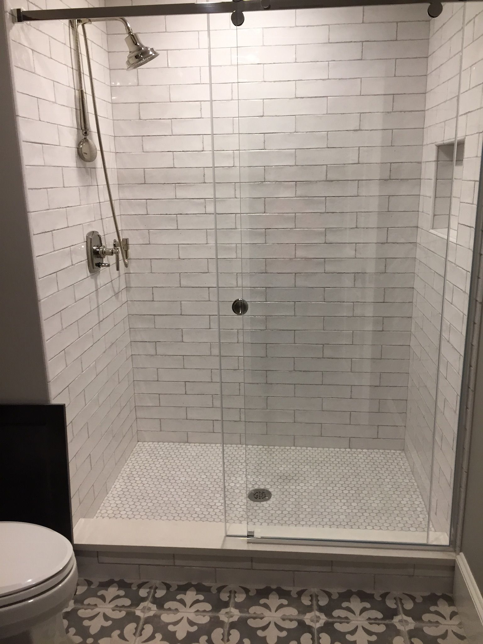 A bathroom with a sliding glass shower door and a toilet.