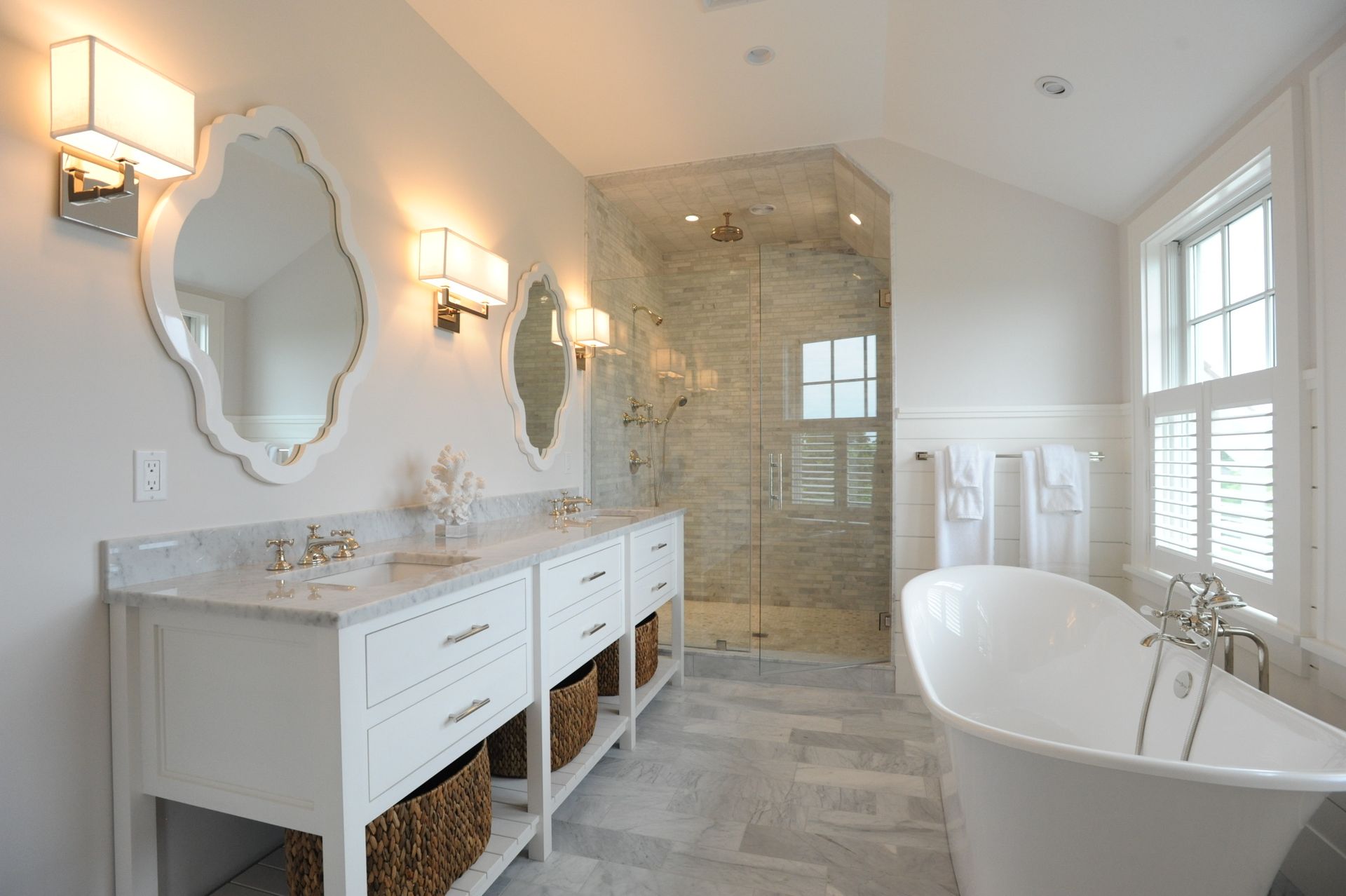 A bathroom with a tub , sinks , mirrors and a walk in shower.