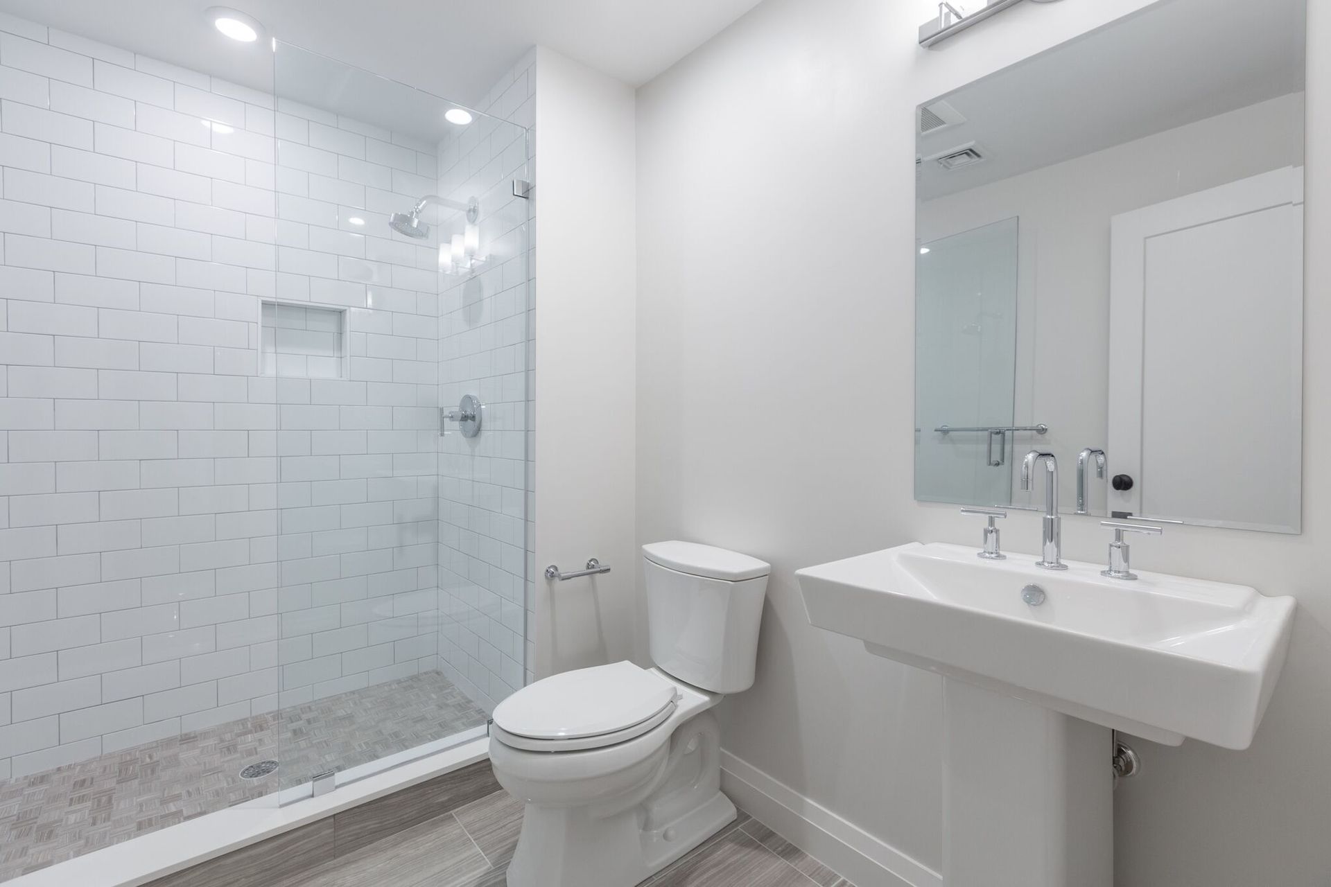 A bathroom with a toilet , sink , and walk in shower.
