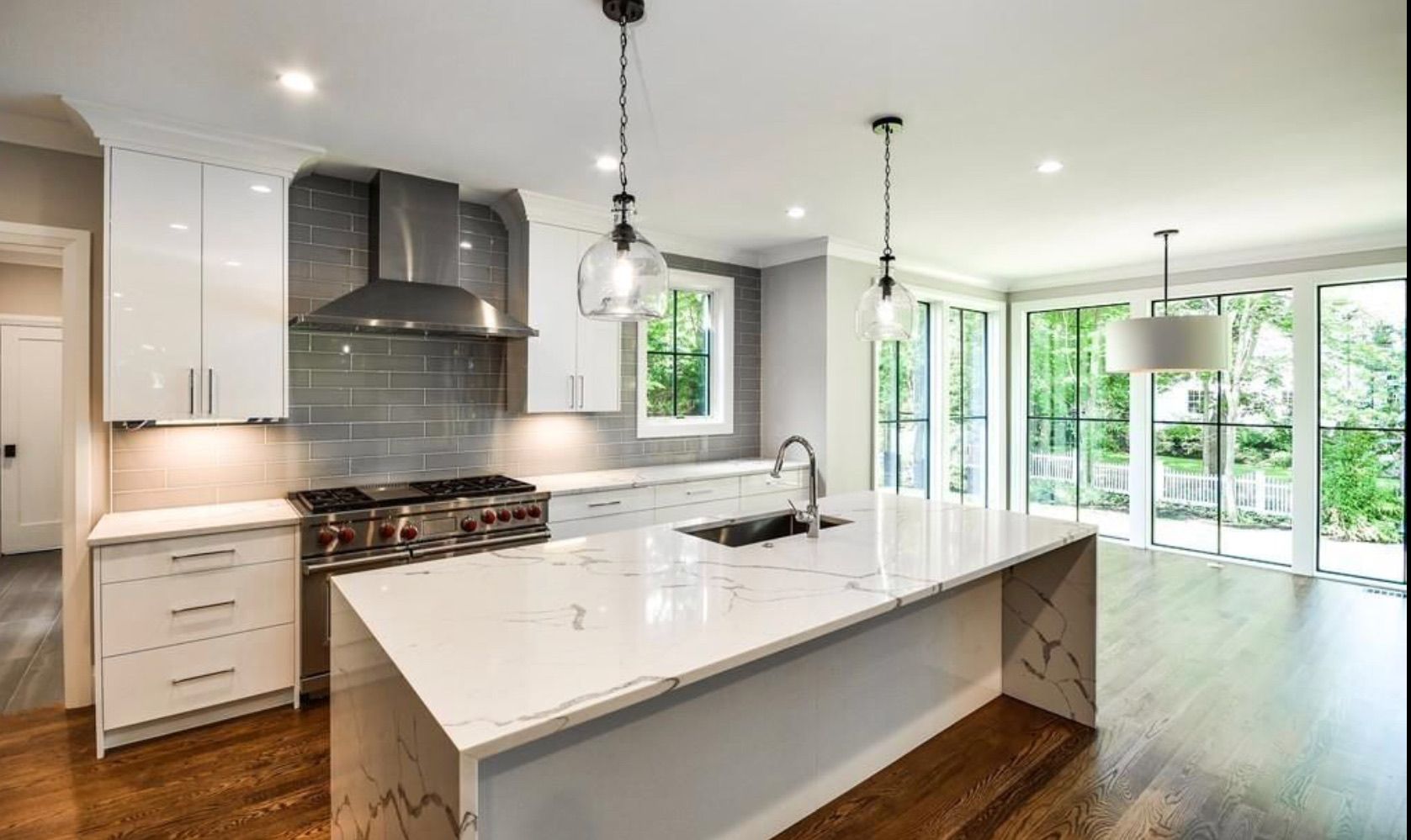 A kitchen with white cabinets and a large island in the middle.