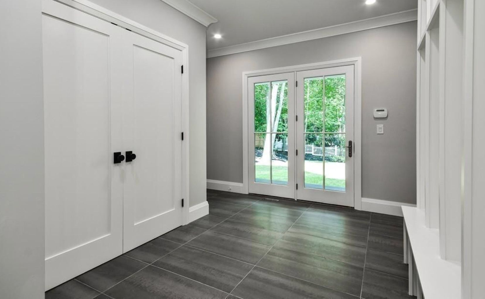 An empty hallway with sliding glass doors and a bench.