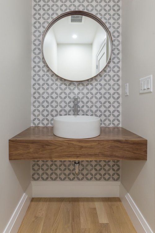 A bathroom with a sink and a mirror on the wall.