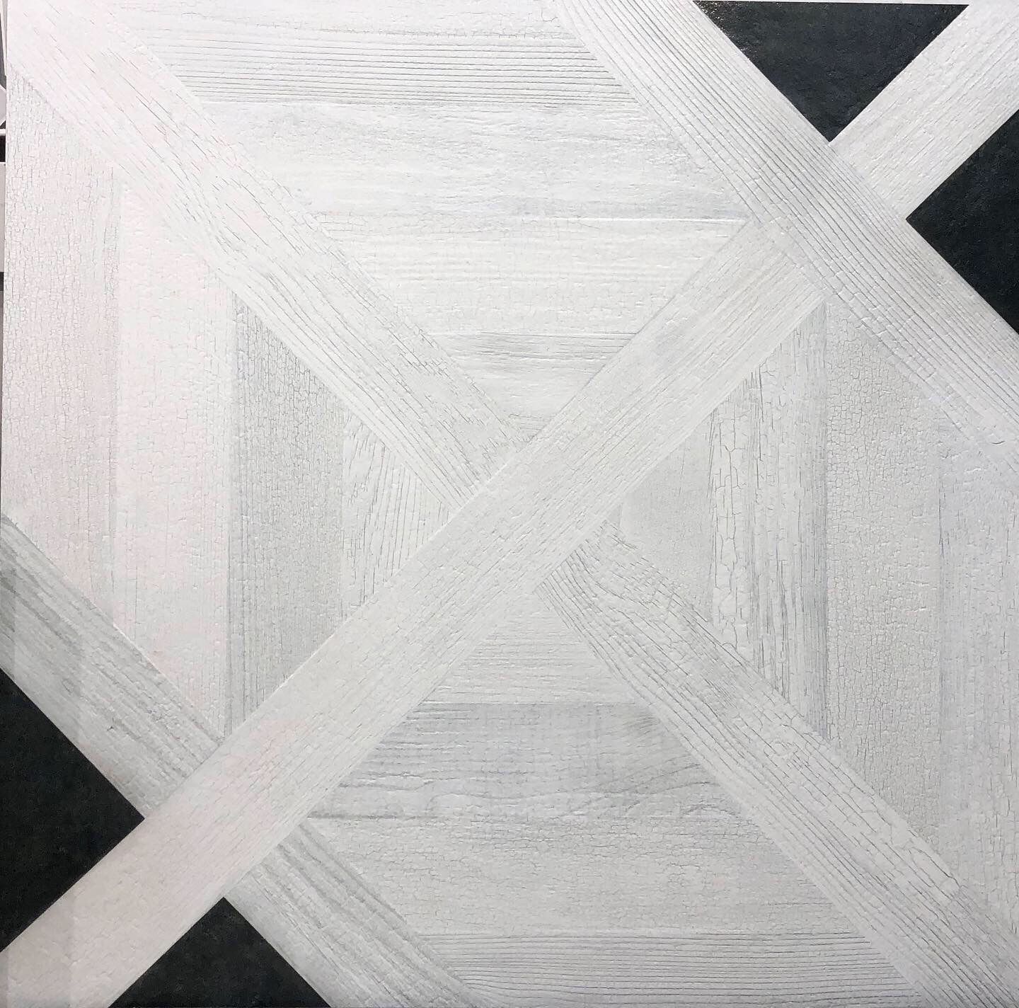 A black and white tile with a geometric pattern on it
