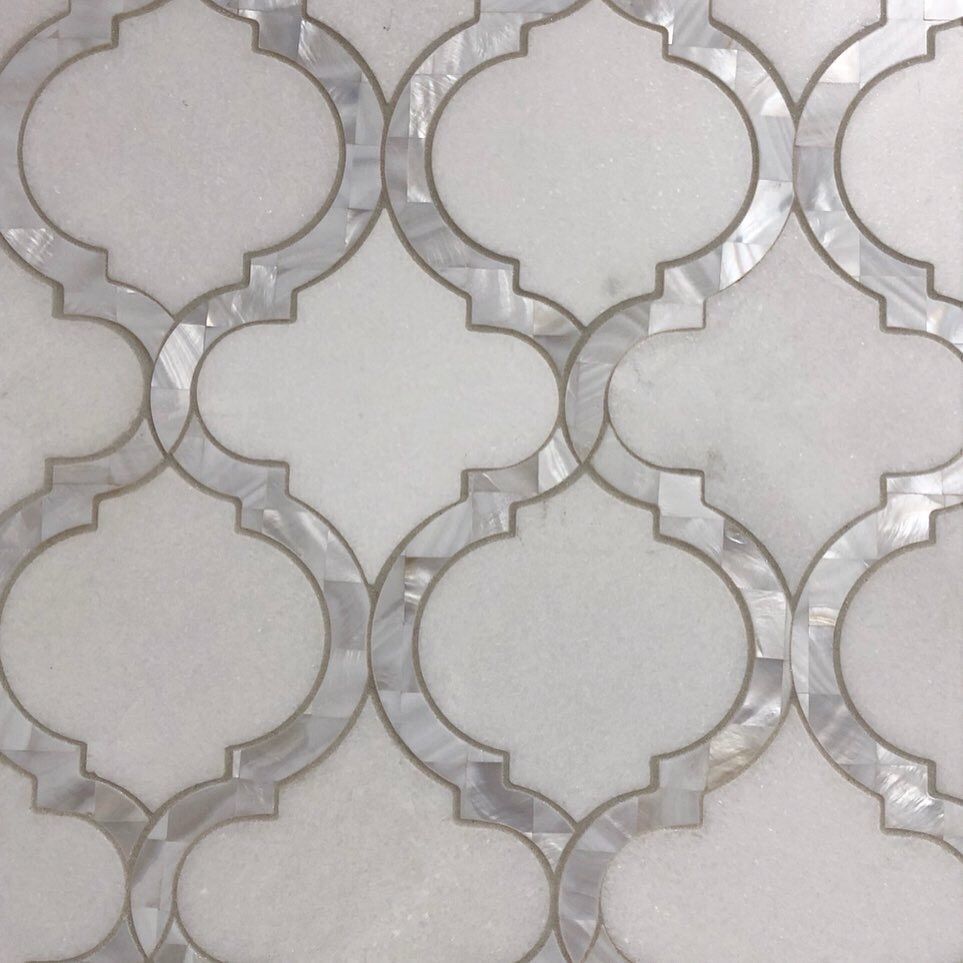 A close up of a white tile with a geometric pattern on it.