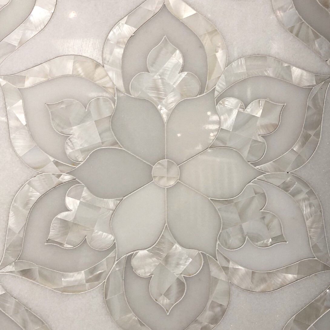 A close up of a white flower on a white surface.