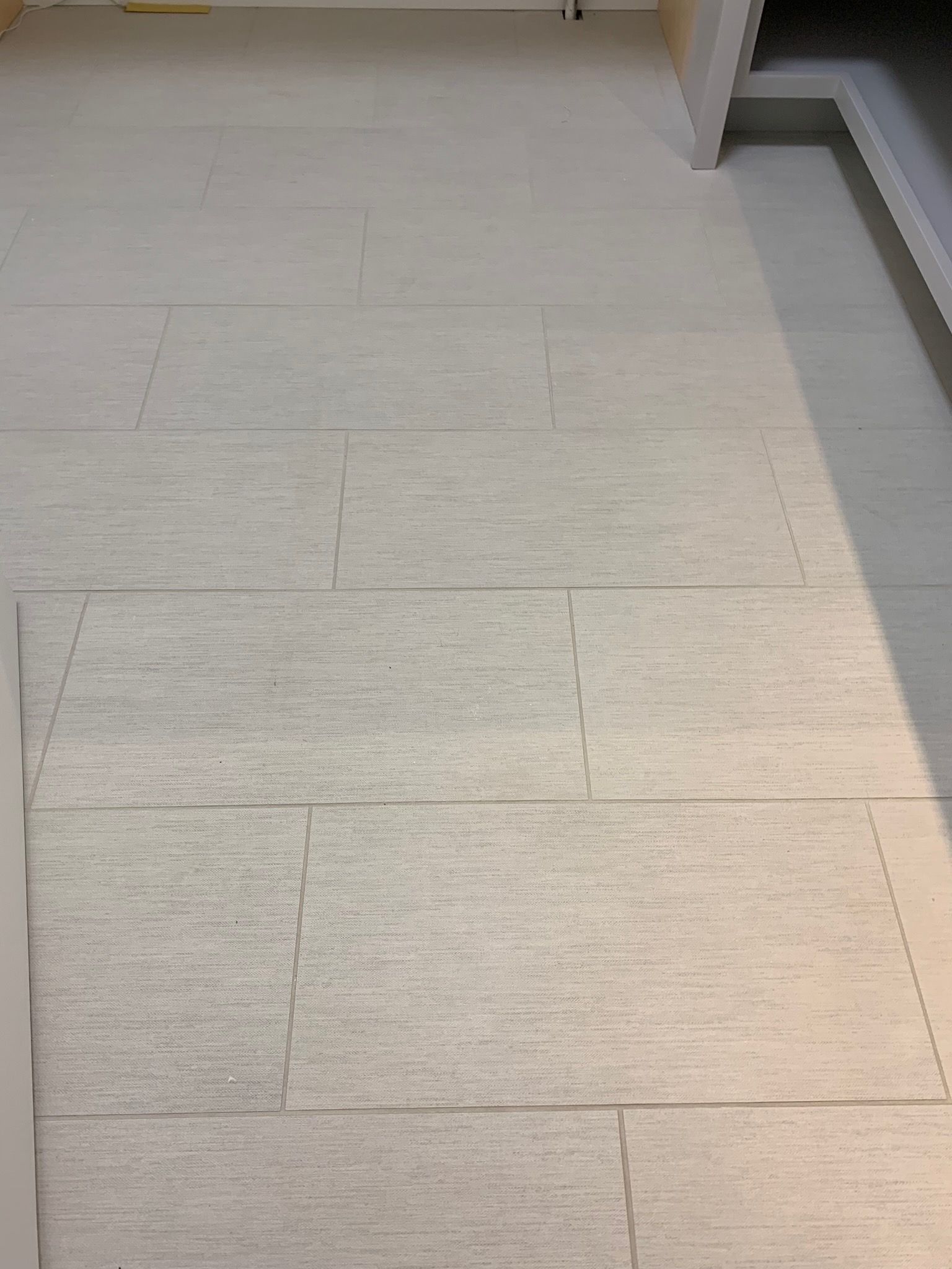 A white tile floor with a shadow on it