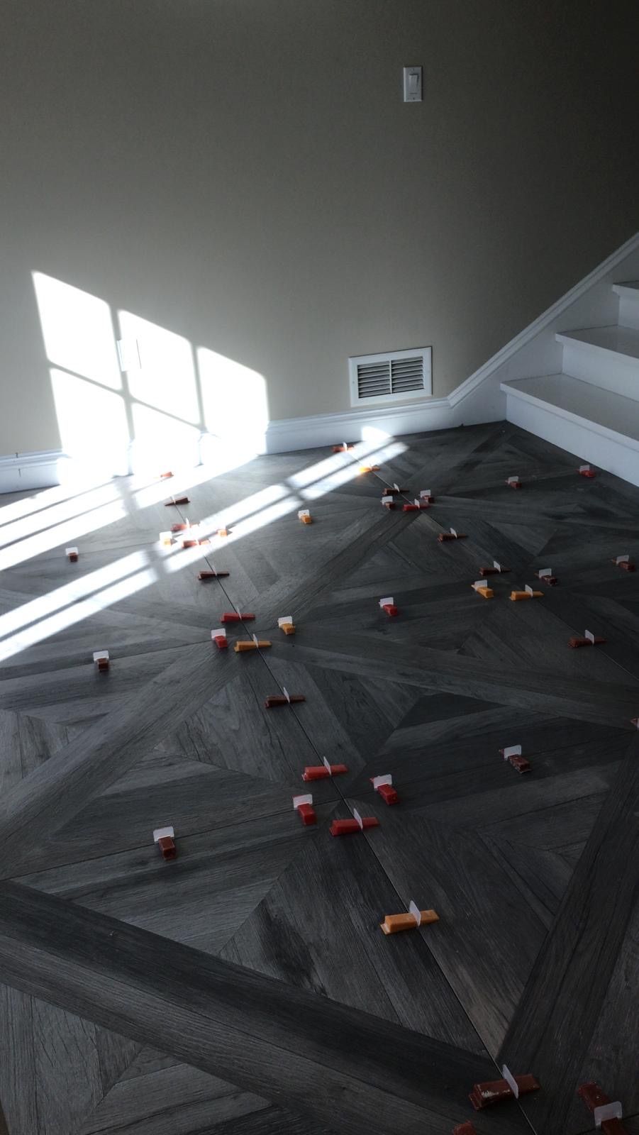 A room with a wooden floor and stairs with petals on the floor.