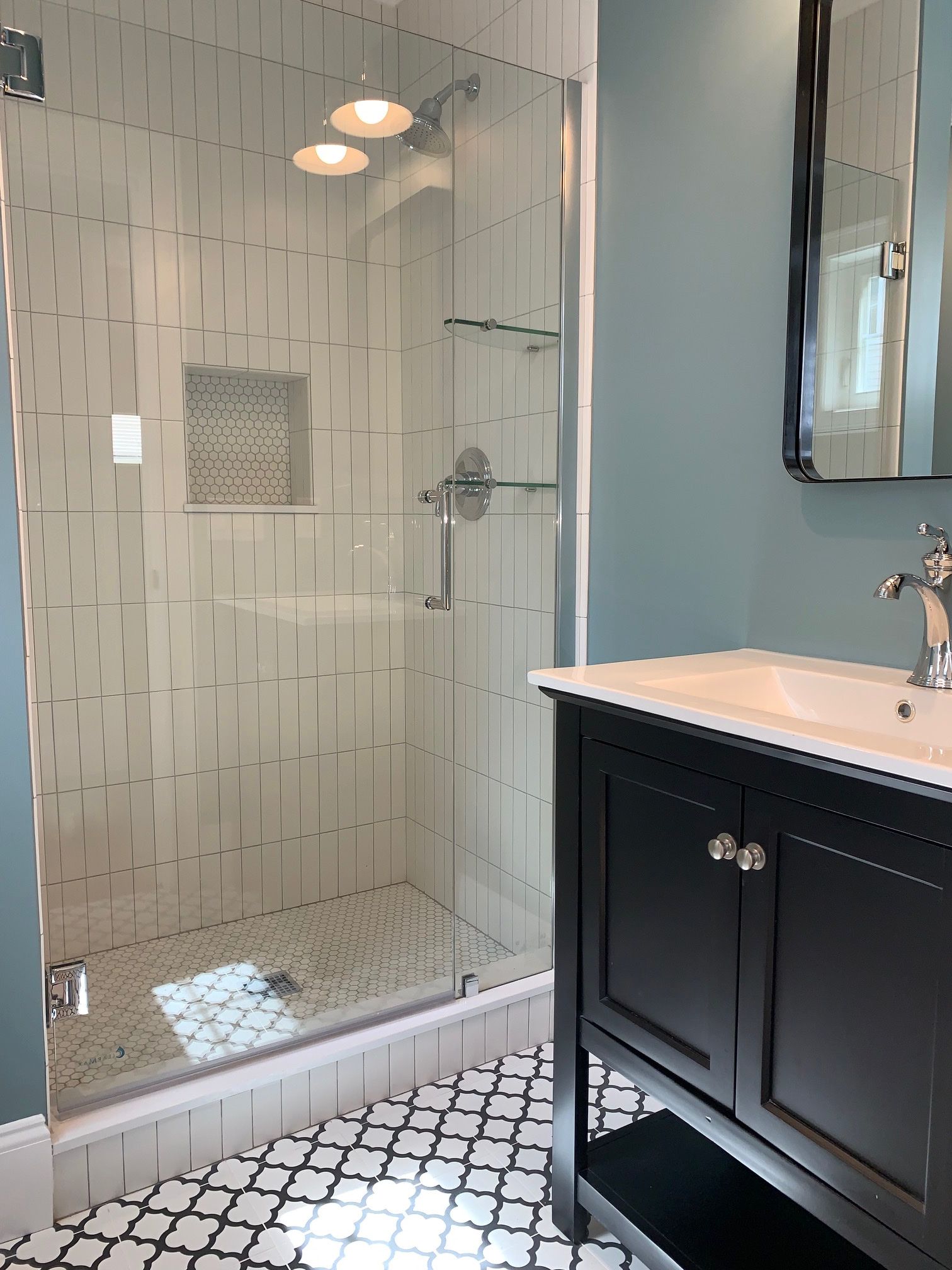 A bathroom with a sink and a walk in shower.