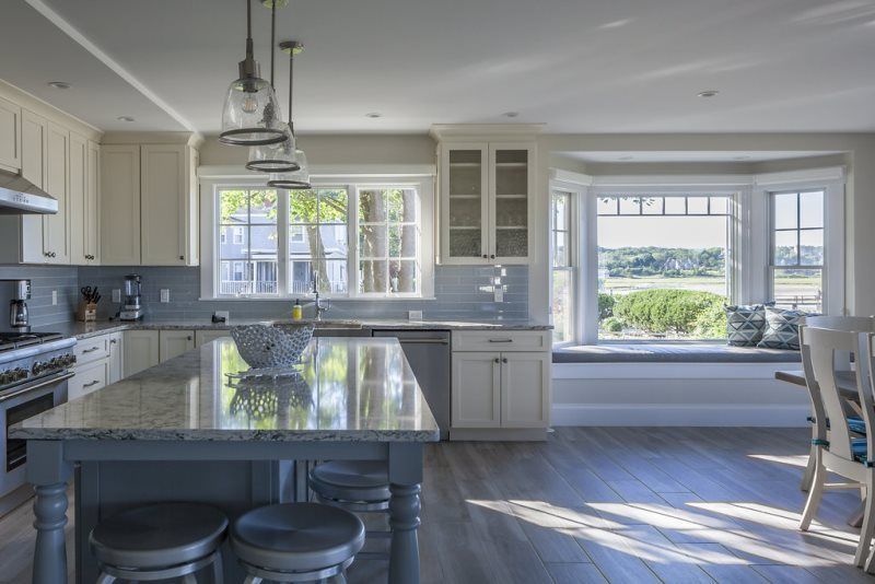 A kitchen with a large island and a bay window.
