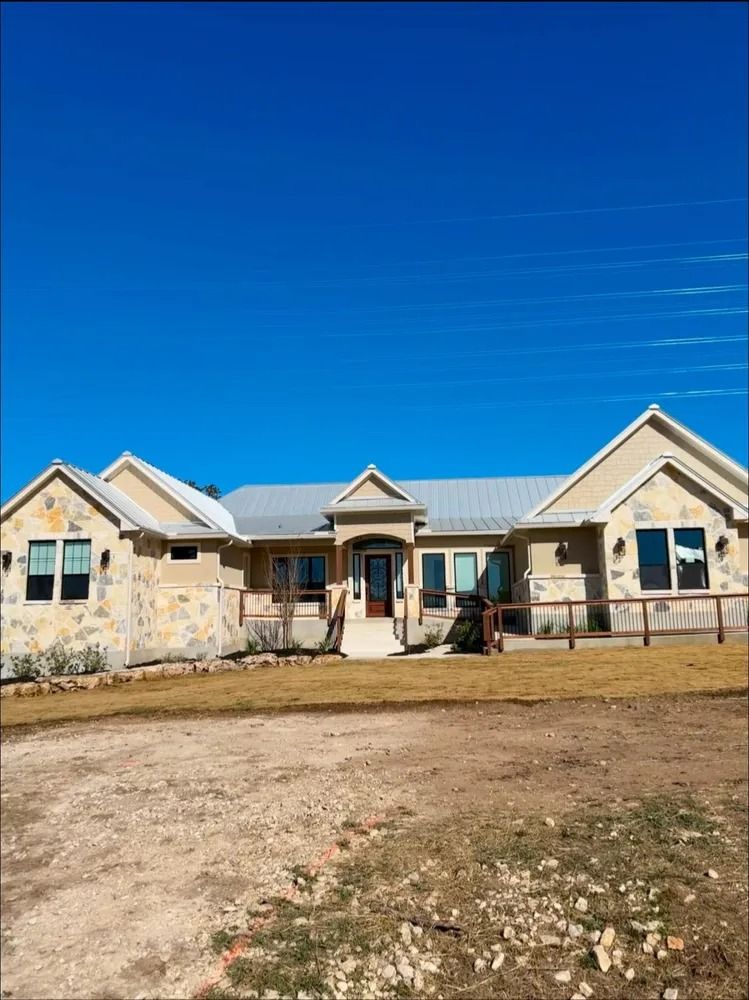 Beige stone house with a blue sky background.