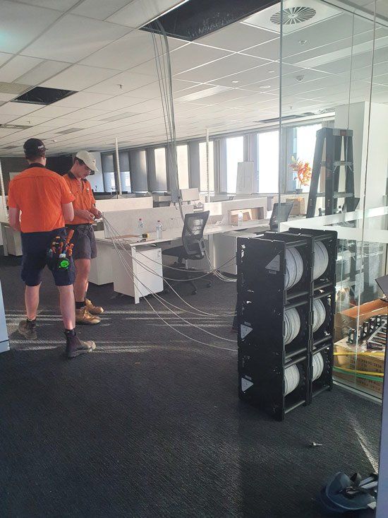 Two Workers Installing Cable Wires in the Office — Office Fit Outs in Toowoomba, QLD