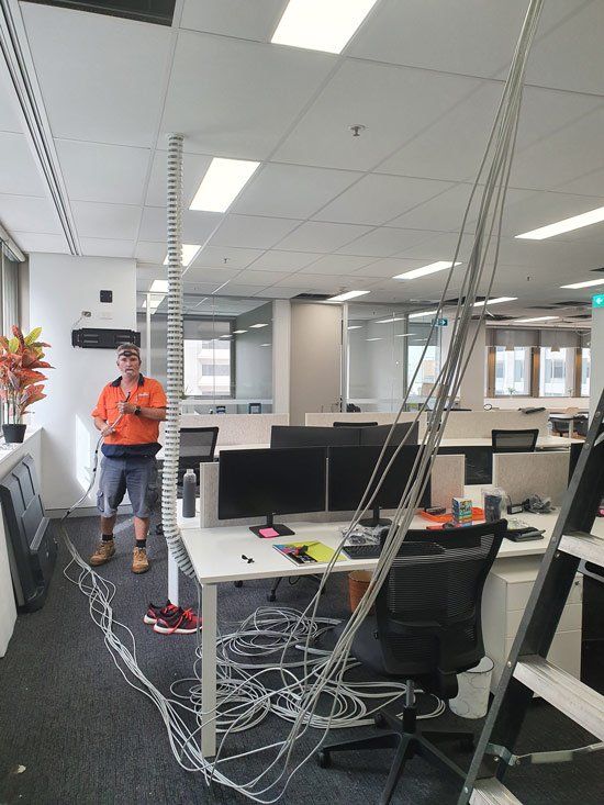 Worker Fixing Cables in the Office — Office Fit Outs in Toowoomba, QLD