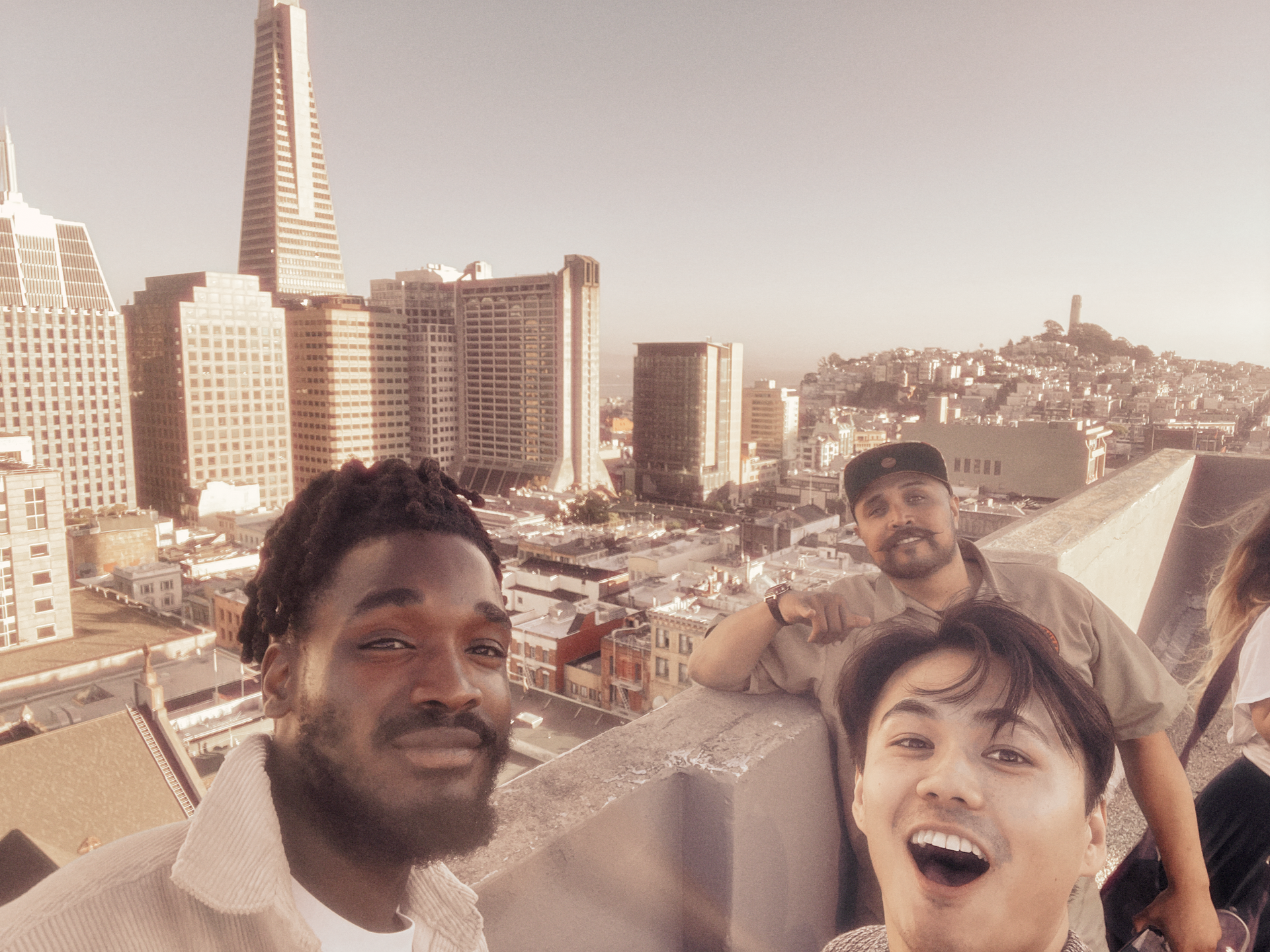 A group of people are posing for a picture with a city in the background.