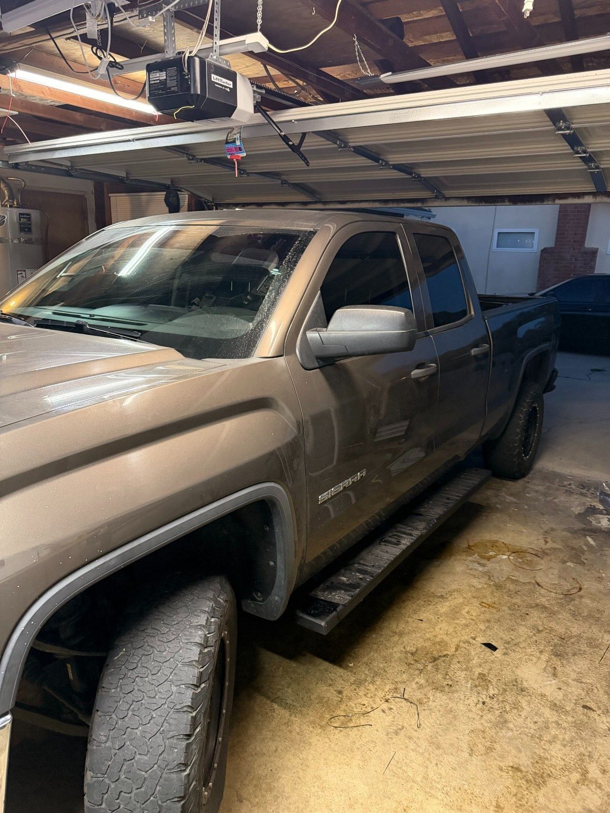 A tan GMC Sierra pickup truck parked inside a garage.