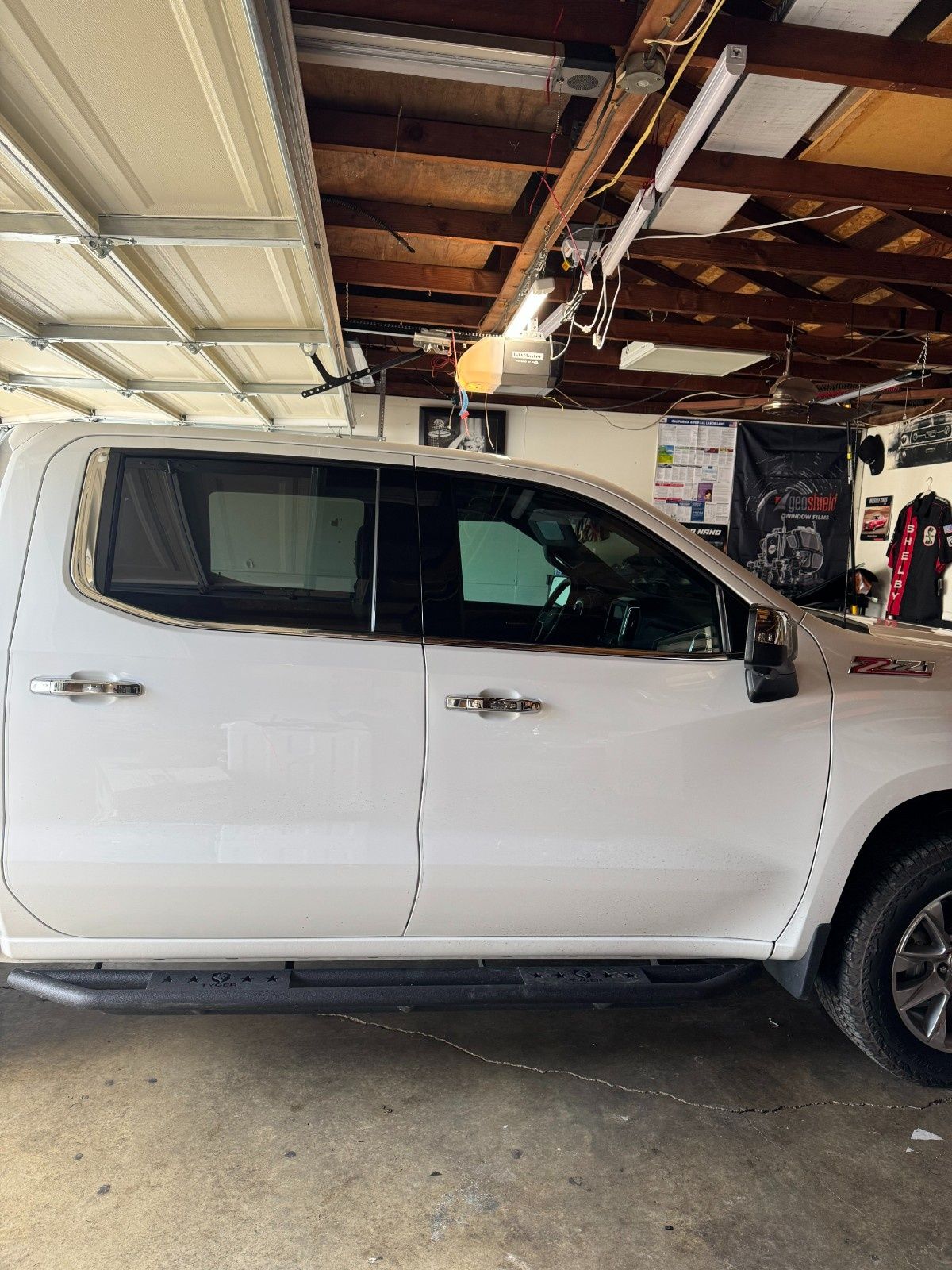 White crew cab pickup truck parked inside a garage.