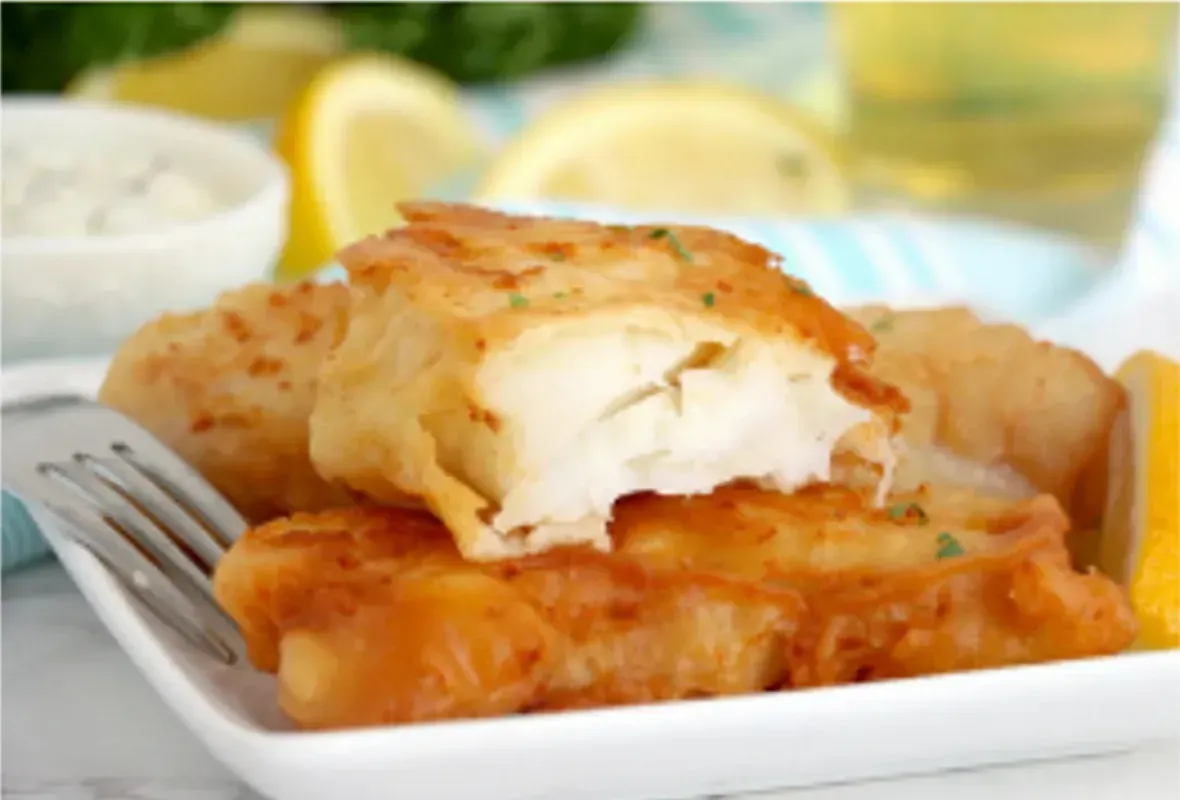 Golden Fried Fish Fillets on a Plate With Lemon Wedges and Sauce — Pt Cartwright Seafoods in Warana, QLD