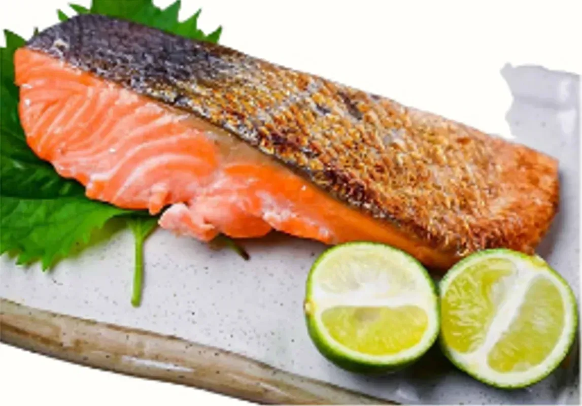 Grilled Salmon Fillet With Lime Halves on a White Plate With Green Leaf — Pt Cartwright Seafoods in Warana, QLD