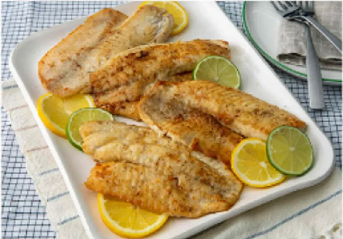 Pan-fried Fish Fillets on a White Platter, Garnished With Lemon and Lime Slices — Pt Cartwright Seafoods in Warana, QLD