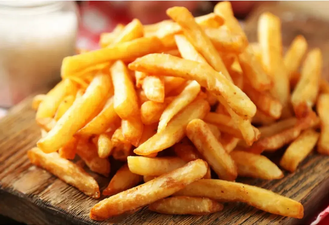 Pile of Golden French Fries on a Wooden Board — Pt Cartwright Seafoods in Warana, QLD