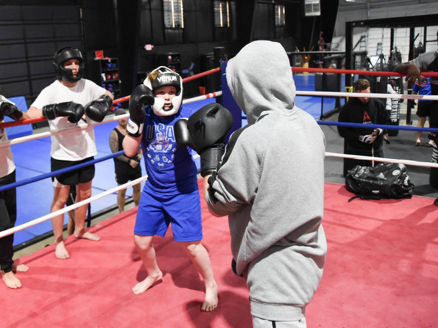 A group of people are boxing in a boxing ring.