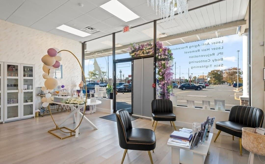Bright modern salon with black chairs, mirrors, balloons, and a glass storefront.
