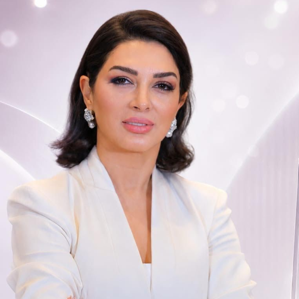Portrait of a woman in a white blazer against a soft lavender background