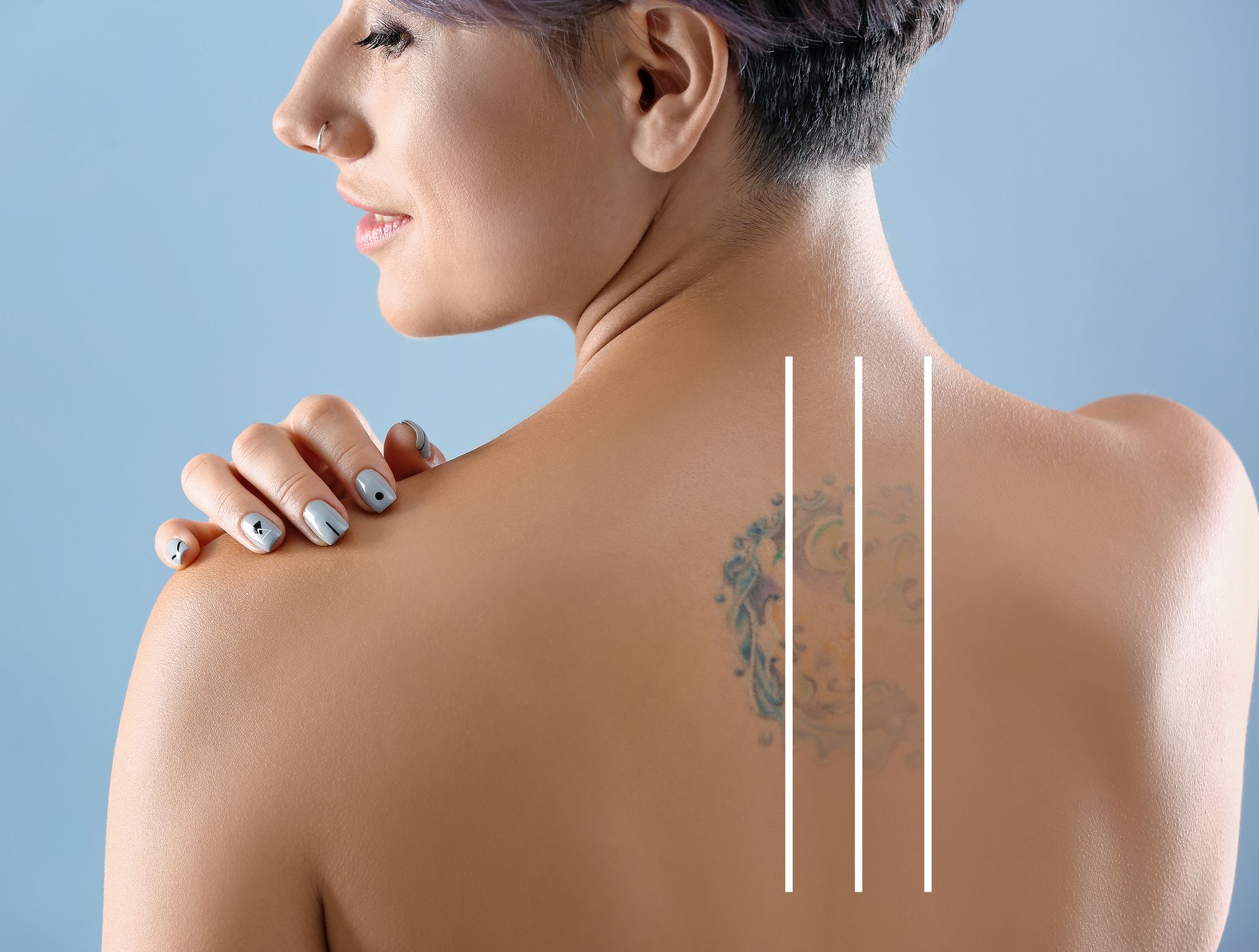Woman touching shoulder with visible back tattoo and three white vertical lines on skin against a blue background